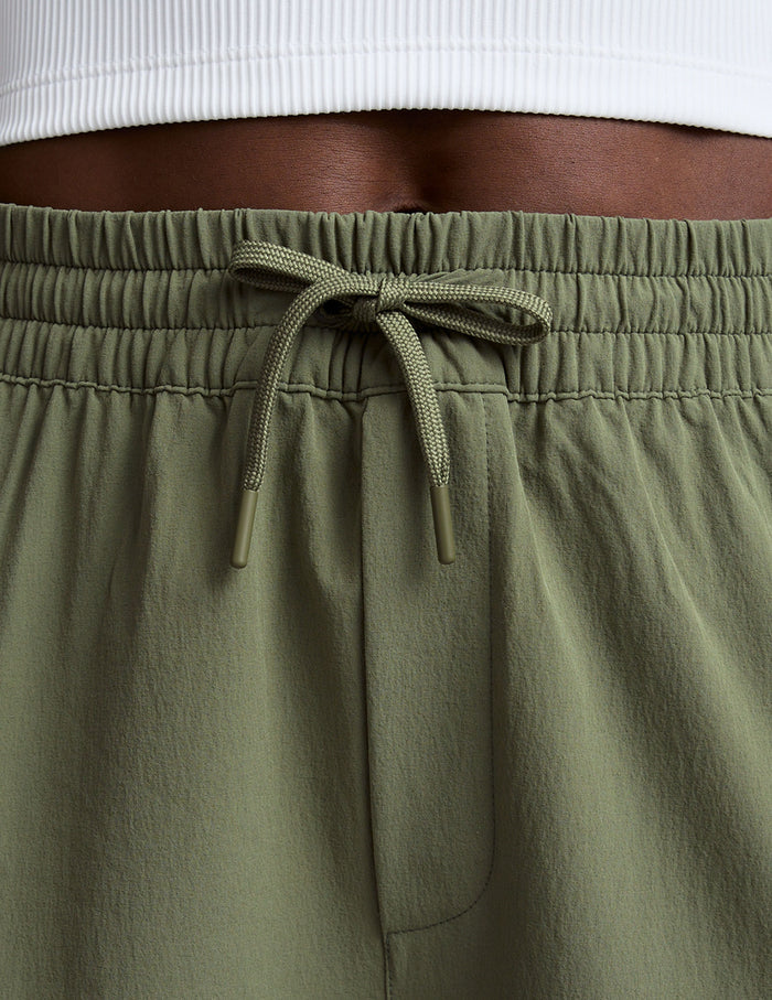 Detail of the olive green Peak Pant featuring a gathered elastic waistband and tied matching drawstring cord.