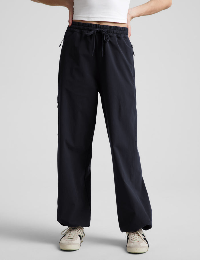 Woman wearing Java Peak Pant™ featuring an elastic drawstring waist, paired with a white tank top and cream sneakers.