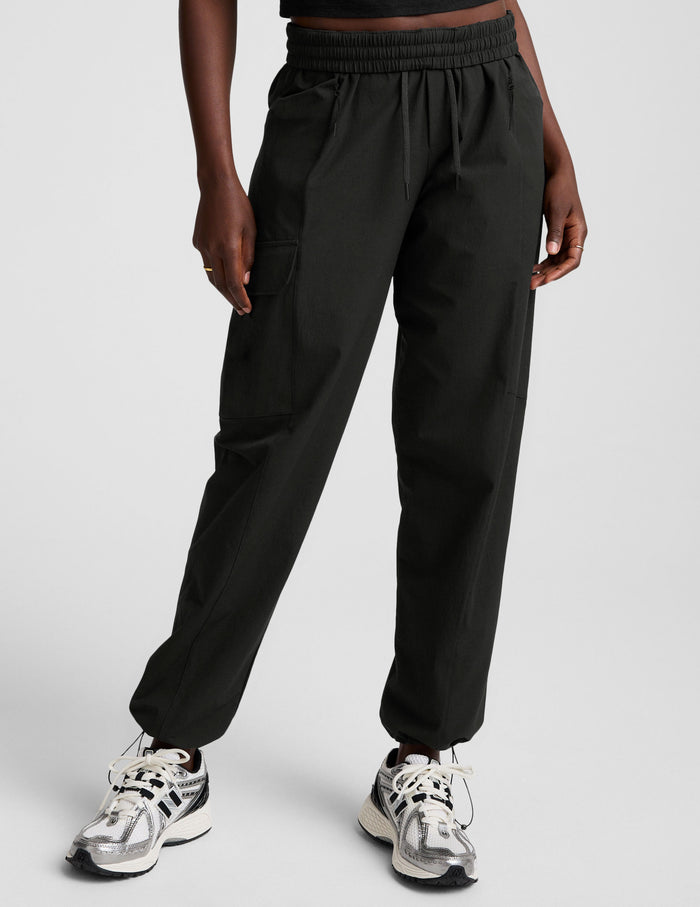 Woman wearing Java Peak Pant with cargo pockets and bungee hems, paired with silver sneakers and a black crop top.