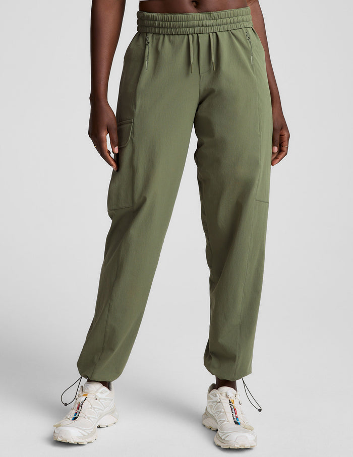 Olive Peak Pant featuring an elastic drawstring waist, side cargo pockets, and adjustable bungee hems worn on a model.