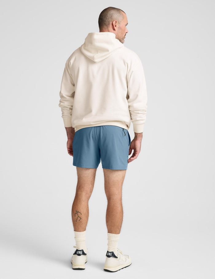 Back view of the blue Pivotal 2.0 Men's Short 5 inch, featuring a relaxed fit and mid-thigh length on a model.