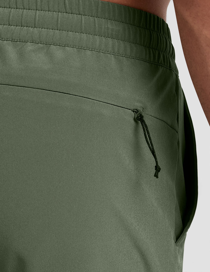 Close-up of olive Pivotal 2.0 Men's Short 5" showing the elastic waistband and a discreet zippered back pocket.