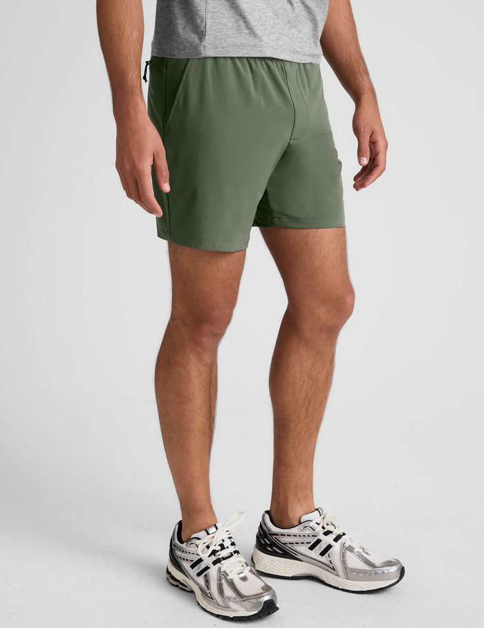 Olive green Pivotal 2.0 Men's Short 7" with an elastic waist and side pockets, shown on a model from the waist down.