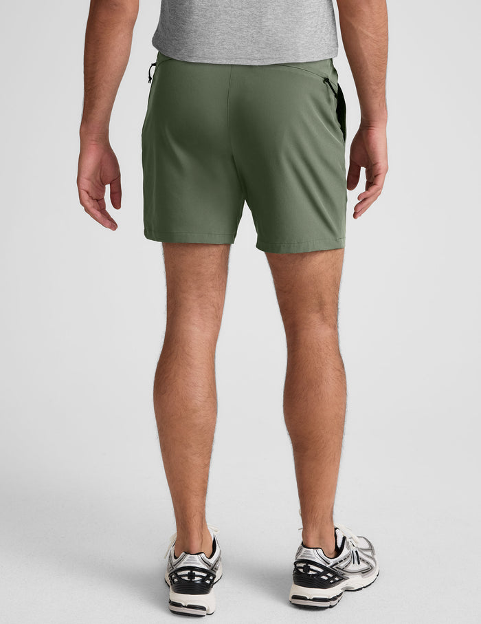 Rear view of olive Pivotal 2.0 Men's Short 7" with a gathered elastic waistband and back zipper pocket on a model.