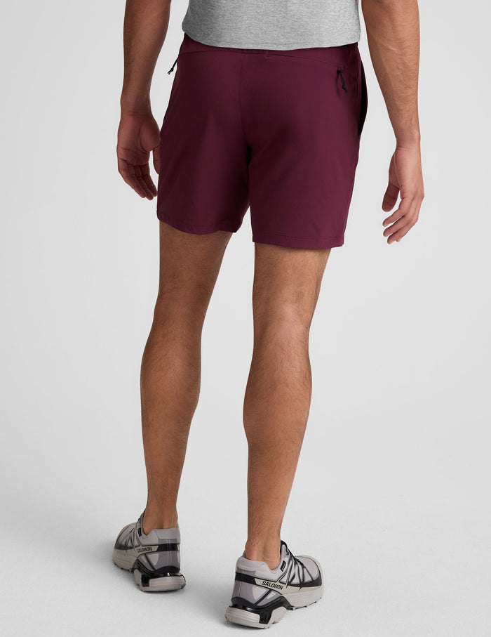 Back view of maroon Pivotal 2.0 Men's Short 7" featuring an elastic waistband and side zipper pockets on a male model.