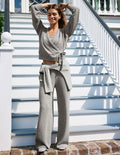 Woman wearing a waffle knit wrap long sleeve top and matching waffle knit lounge pants.