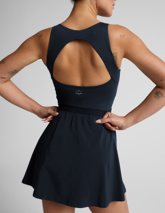Woman wearing a blue dress against a plain background.