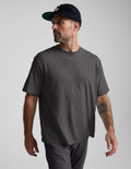 Man wearing a black cotton tee and pants against a plain background.