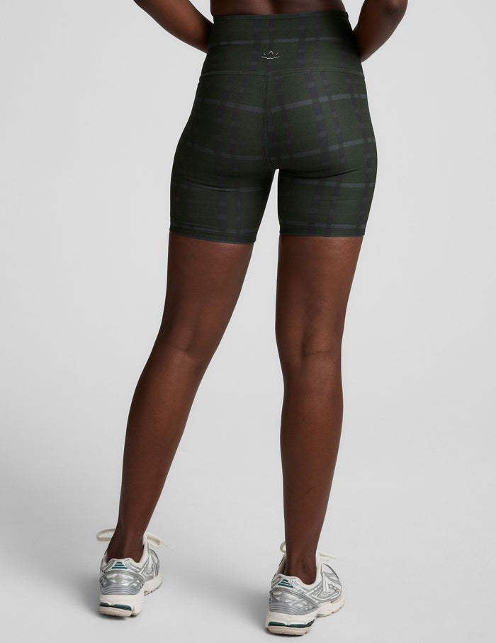 Rear view of SoftMark Keep Pace Biker Short in emerald green plaid, showing the high-waisted fit and 5-inch inseam.