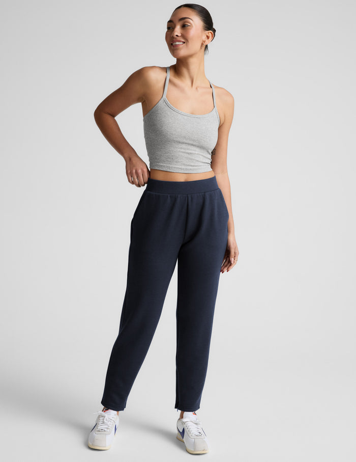 Navy SoftSpring Tapered Pant on a smiling model. Features mid-rise elastic waistband and ankle-length tapered fit.