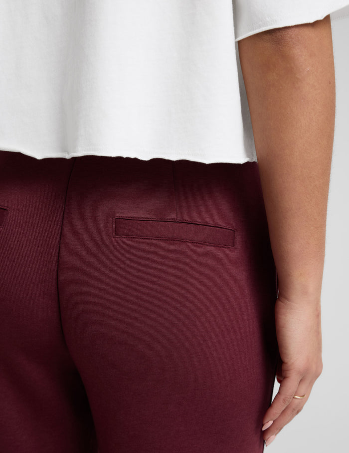 Close-up back view of the maroon SoftSpring Tapered Pant highlighting the welt pocket and smooth fabric texture.