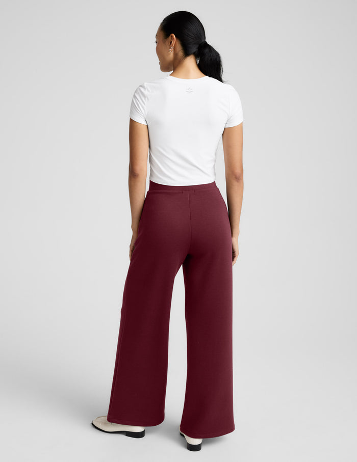 Back view of the maroon SoftSpring Wide Leg Pant showing the relaxed wide-leg fit and mid-rise elastic waistband on a model.