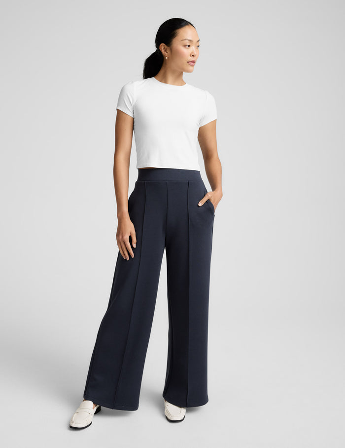 SoftSpring Wide Leg Pant 31" in black with front pintuck folds and a wide leg, styled with a white tee and loafers.