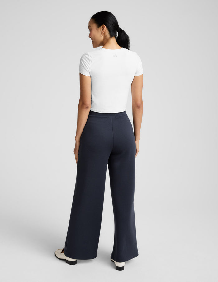 Rear view of the black SoftSpring Wide Leg Pant on a model, featuring a relaxed wide-leg silhouette and mid-rise waistband.