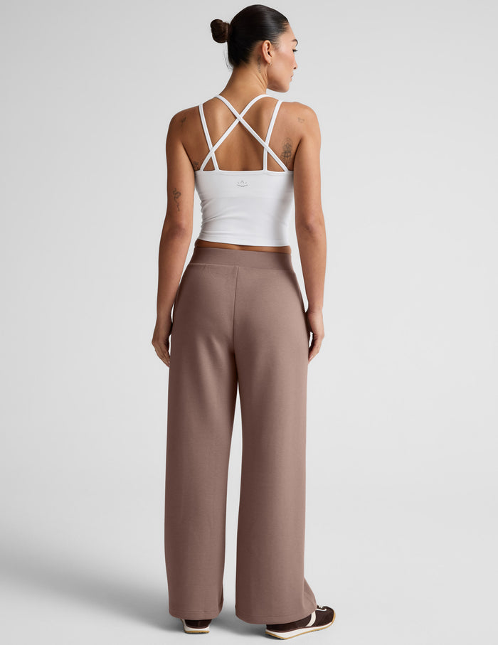 Back view of SoftSpring Wide Leg Pant in beige, featuring a mid-rise elastic waistband and full-length relaxed fit.