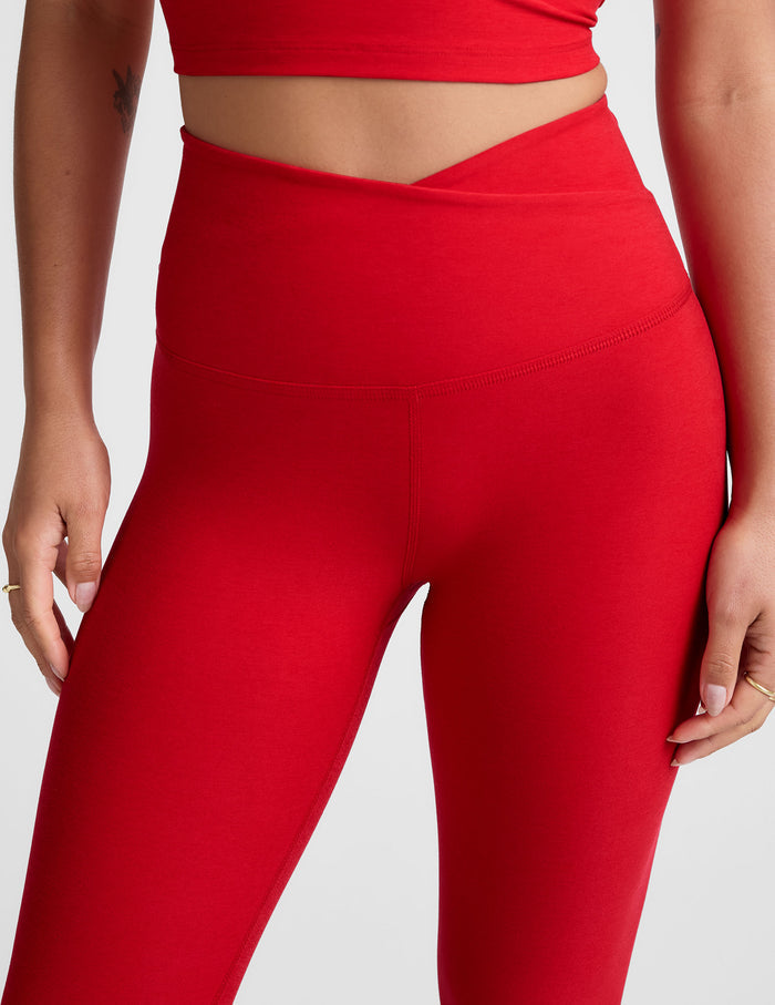 red high-waisted midi legging with criss cross front detail.