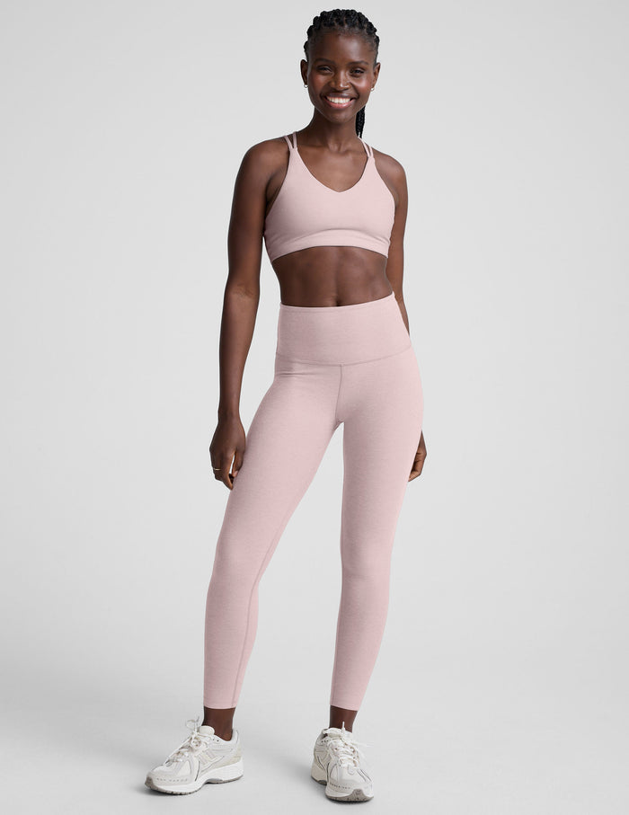 Woman wearing a pink athletic outfit on a white background