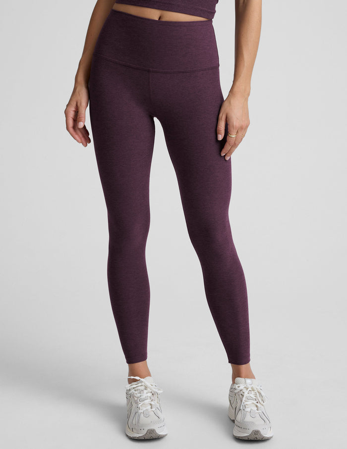 Woman wearing a purple athletic outfit on a gray background.
