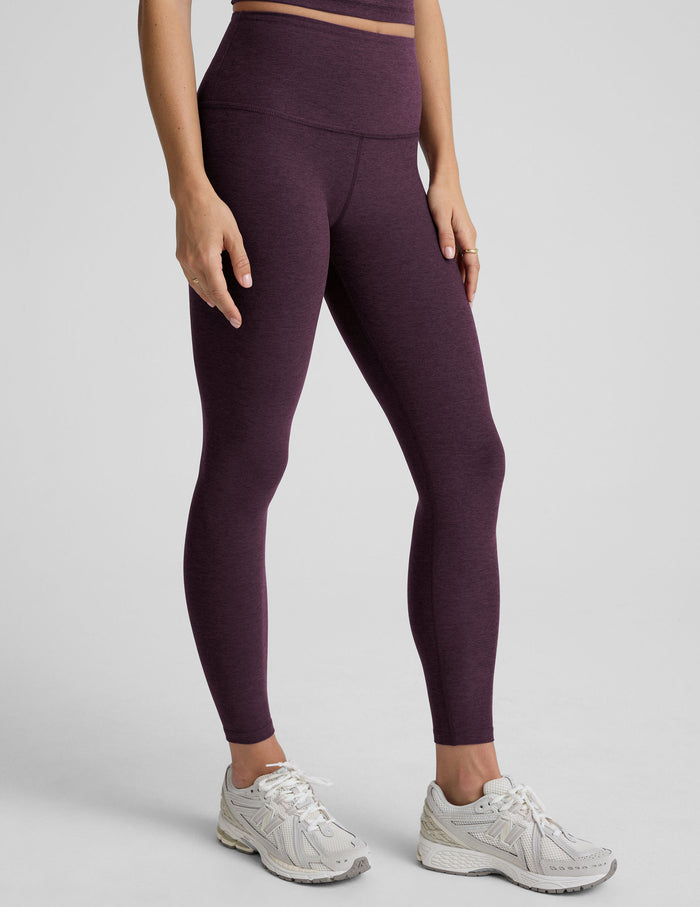 Woman wearing a purple athletic outfit on a gray background.