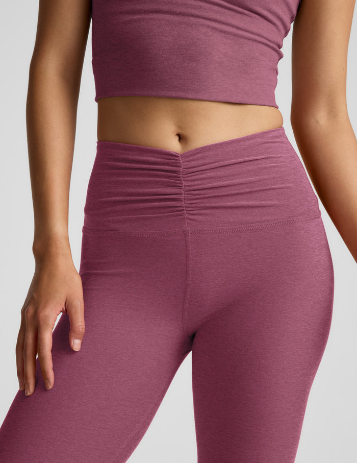 Person wearing a pair of purple leggings on a plain background.