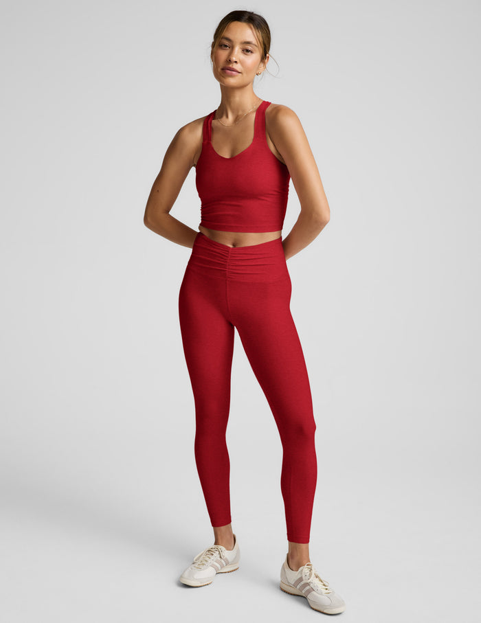 Woman wearing a red athletic outfit on a light gray background.