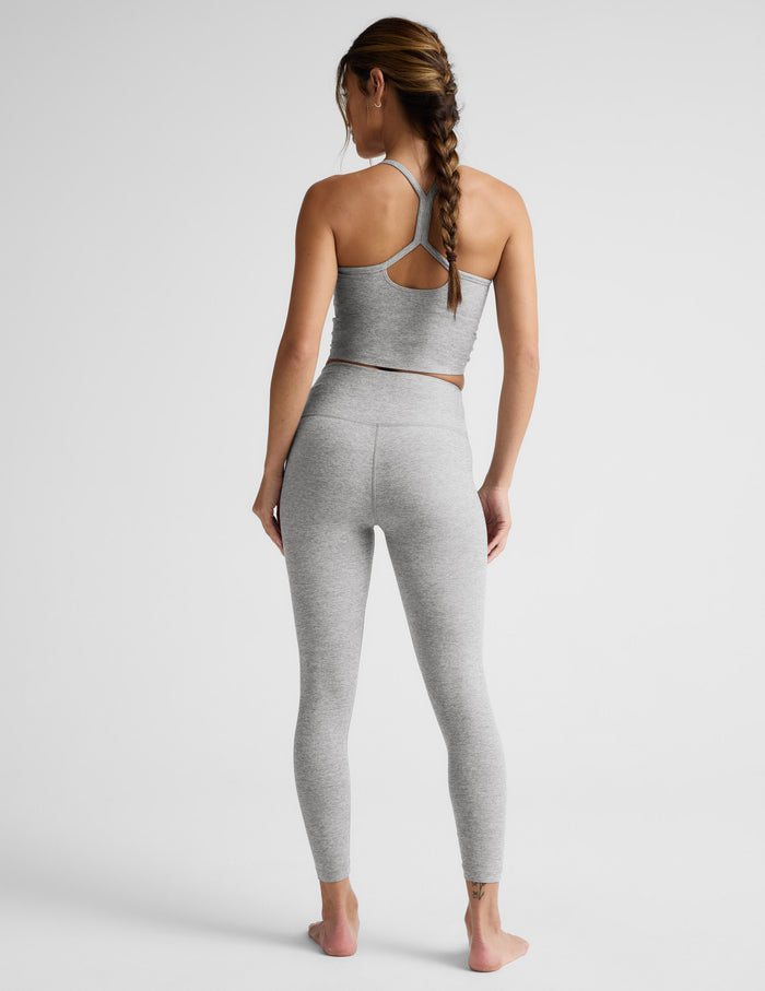 Woman wearing a gray athletic outfit on a white background.