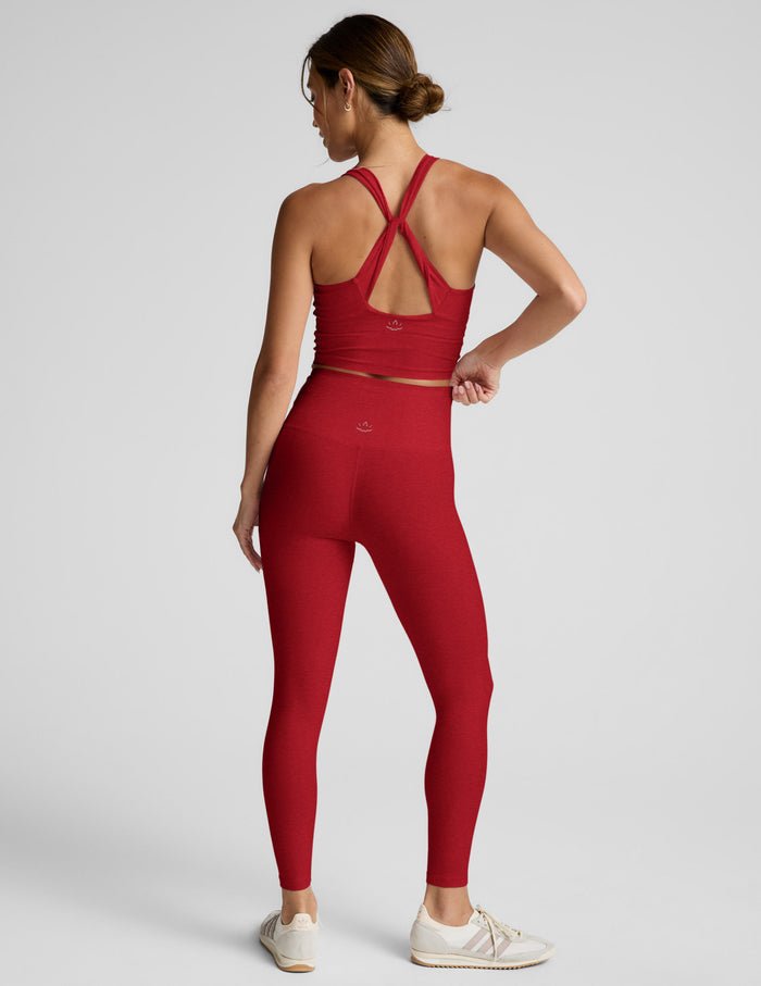 Woman wearing a red athletic outfit on a light gray background.