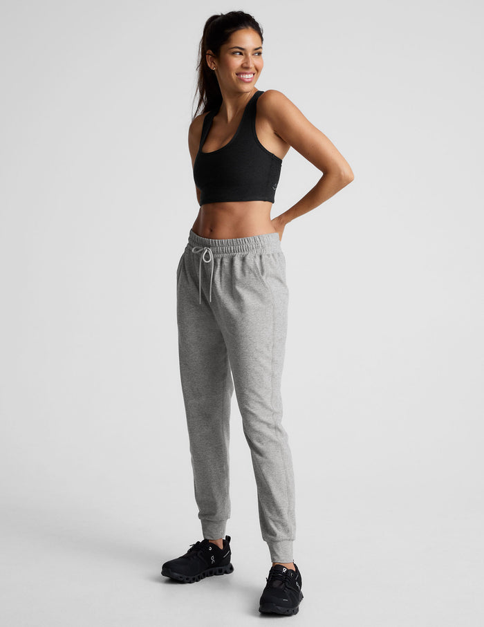 Smiling woman in gray marled Spacedye Commuter Midi Jogger with a high drawstring waist, slim fit, and banded cuffs.