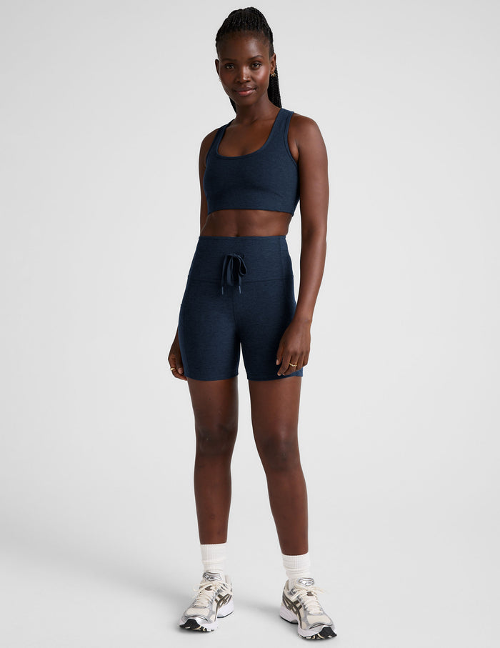 Front view of a woman wearing navy Spacedye Go Pocket 5" Short featuring a high waist, drawstring, and side pockets.