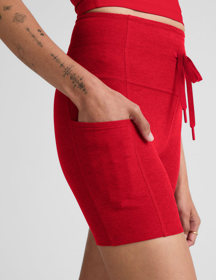 Red Spacedye Go Pocket 5" Short with high waistband, drawstring detail, and a hand resting in the side pocket.