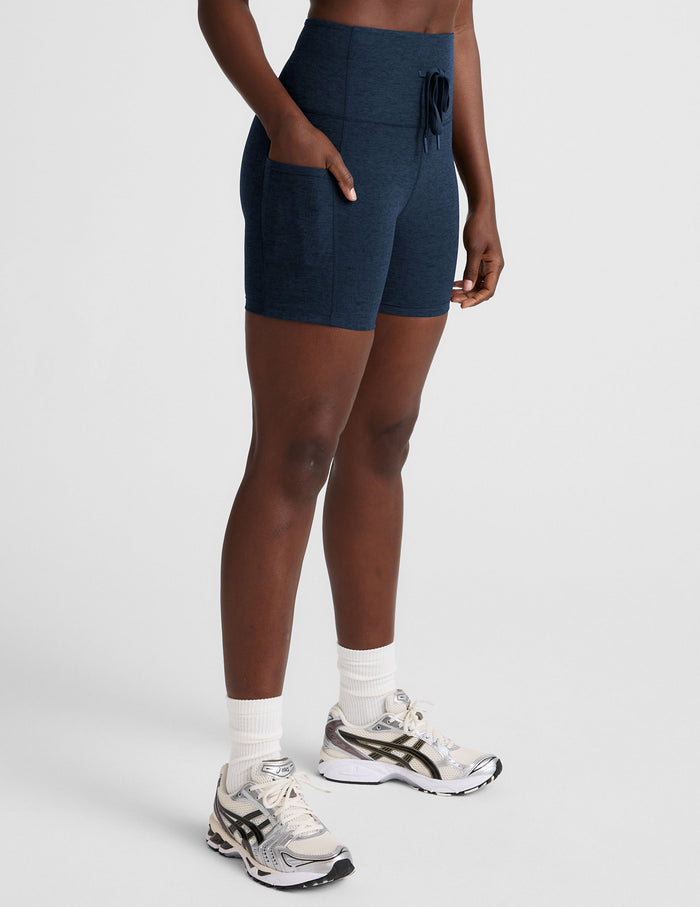 Spacedye Go Pocket 5" Short in navy. Side view of high-waist bike shorts featuring side pockets and a front drawstring tie.