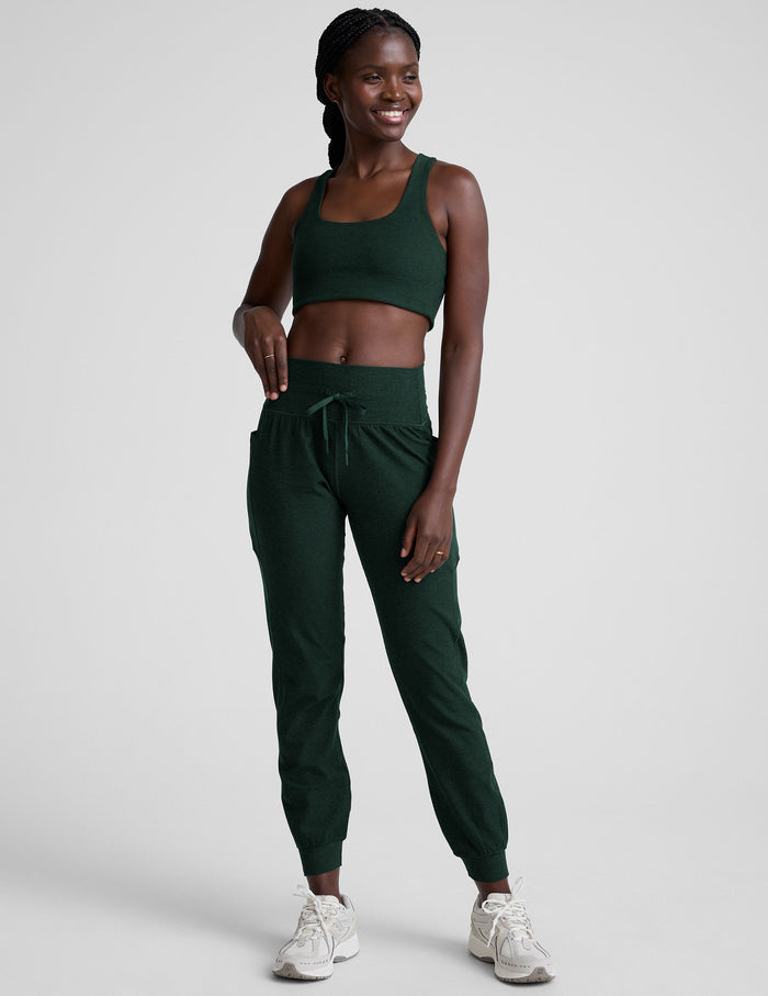 Woman in emerald Spacedye Go Pocket Jogger with high waistband, drawstrings, side pockets, and cuffed ankle hems.