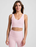 Woman wearing a pink athletic outfit on a plain background