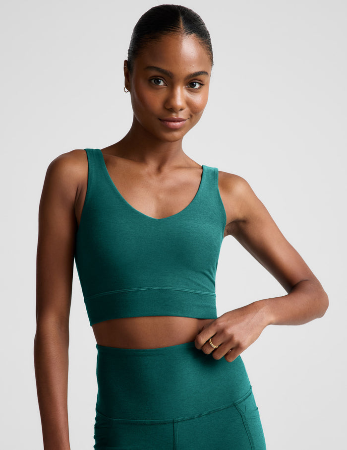 Woman wearing a green athletic outfit on a plain background.