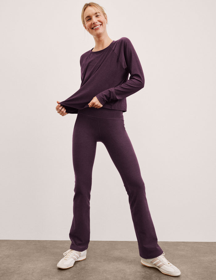 Purple Spacedye High Waisted Practice Pocket Bootcut Pant on a model with flared legs and a matching long-sleeve top.