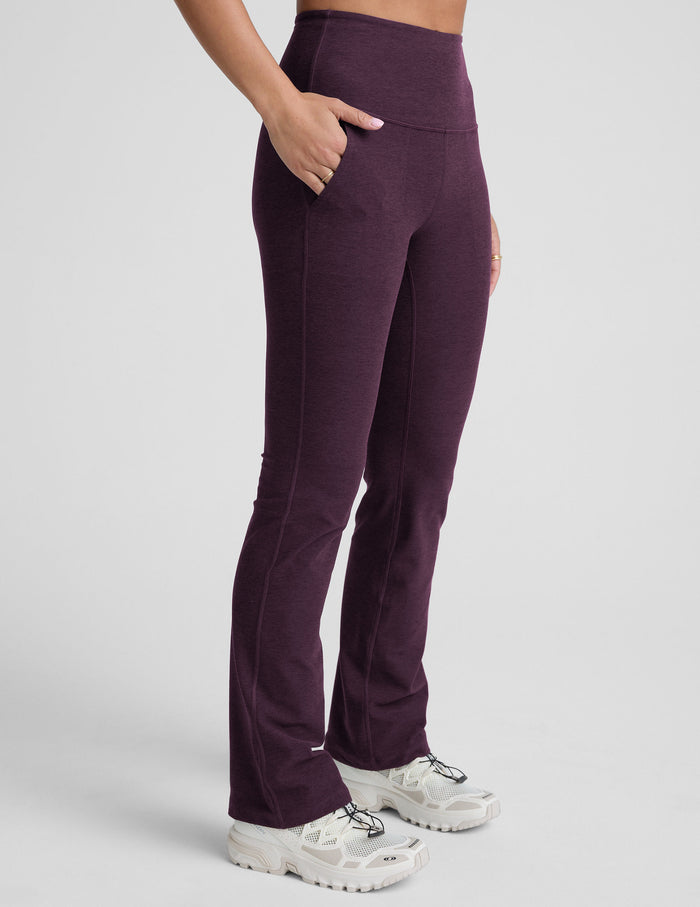 Side view of purple Spacedye High Waisted Practice Pocket Bootcut Pant with a hand in the front pocket and flared hem.