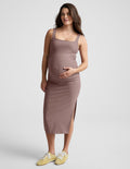 Woman wearing a brown maternity midi length dress against a plain background.