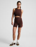 Woman wearing Brown Spacedye™ Keep Pace 5" Pocket Short with side pockets, paired with a matching knotted tank top.