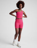 Front view of a woman wearing the marled fuchsia Spacedye Keep Pace 5" Short with a high waistband and matching crop top.
