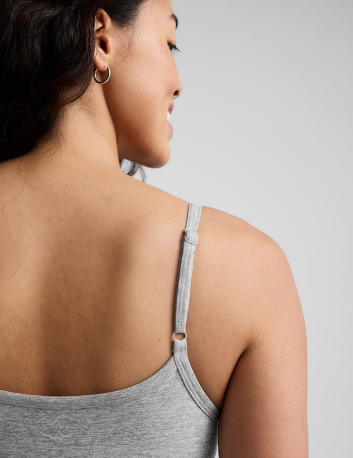 Woman wearing a gray short bodysuit against a plain background.