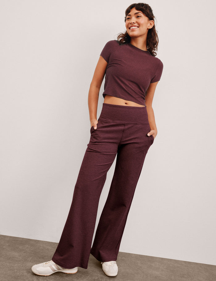Maroon Spacedye Laid Back Wide Leg Pant with a high waistband and side pockets on a smiling model with hands in pockets.