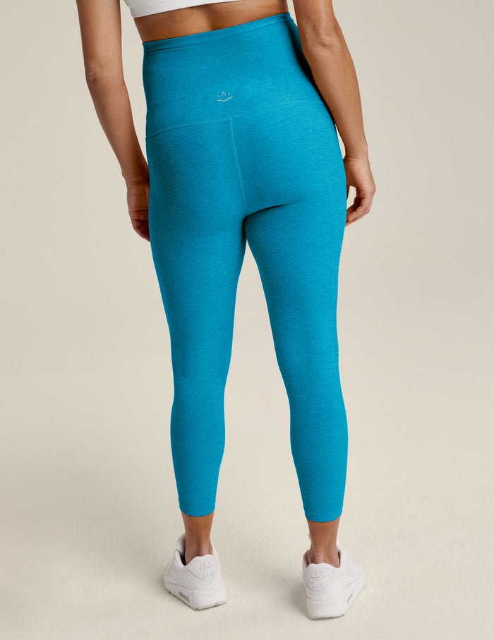 Woman wearing Cali Blue Heather Spacedye™ Love The Bump Capri Maternity Legging, rear view, with white sneakers.