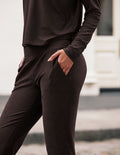 Side view of dark marled Spacedye Midi Jogger with a hand in the slant pocket, showing the slim fit and wide waistband.