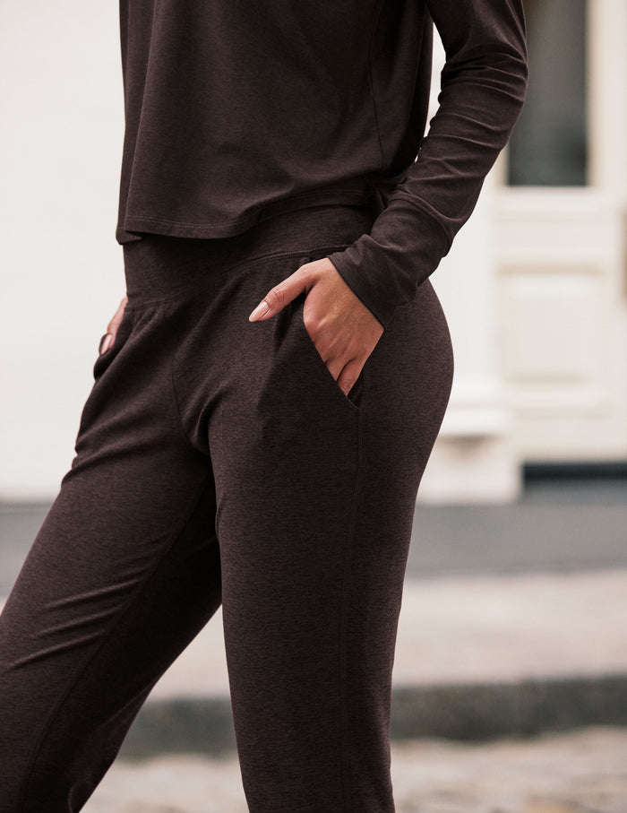 Side view of dark marled Spacedye Midi Jogger with a hand in the slant pocket, showing the slim fit and wide waistband.
