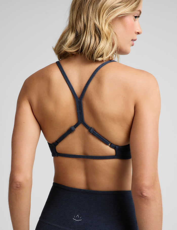Woman wearing a blue sports bra and biker shorts against a plain background.