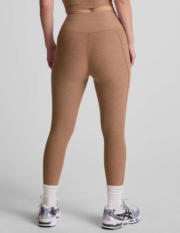 Rear view of brown Spacedye Out Of Pocket High Waisted Capri Legging featuring a marled texture and functional side pockets.