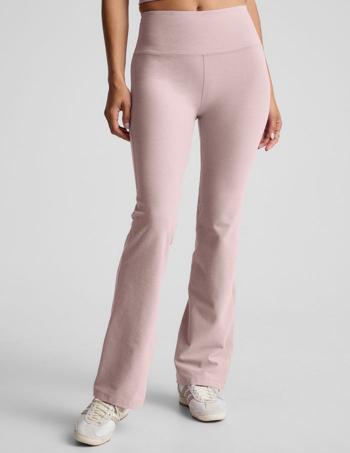 Spacedye Practice High Waisted Bootcut Pant in light pink with a wide waistband and flared leg over white sneakers.