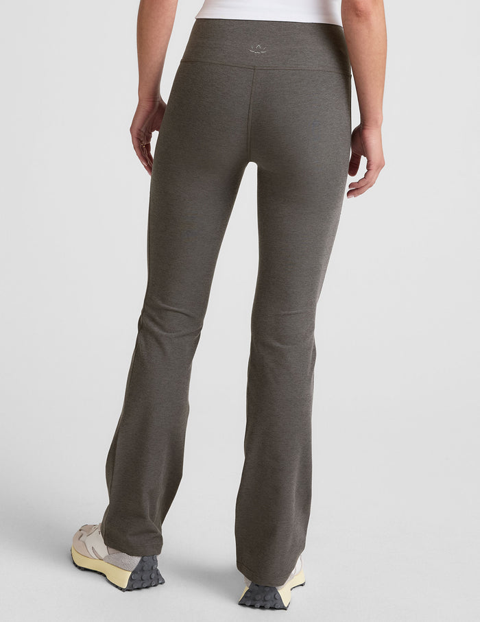 Rear view of the gray Spacedye Practice High Waisted Bootcut Pant featuring a snug fit and flared, full-length legs.