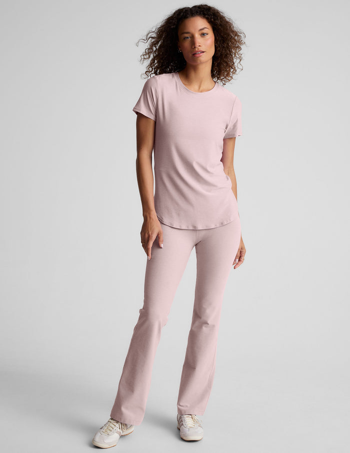 Front view of woman wearing pastel Spacedye Practice High Waisted Bootcut Pant with a snug fit and wide leg opening.