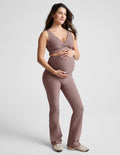 Pregnant woman in blush Spacedye Practice Maternity Pant with high waistband over bump and a matching v-neck top.